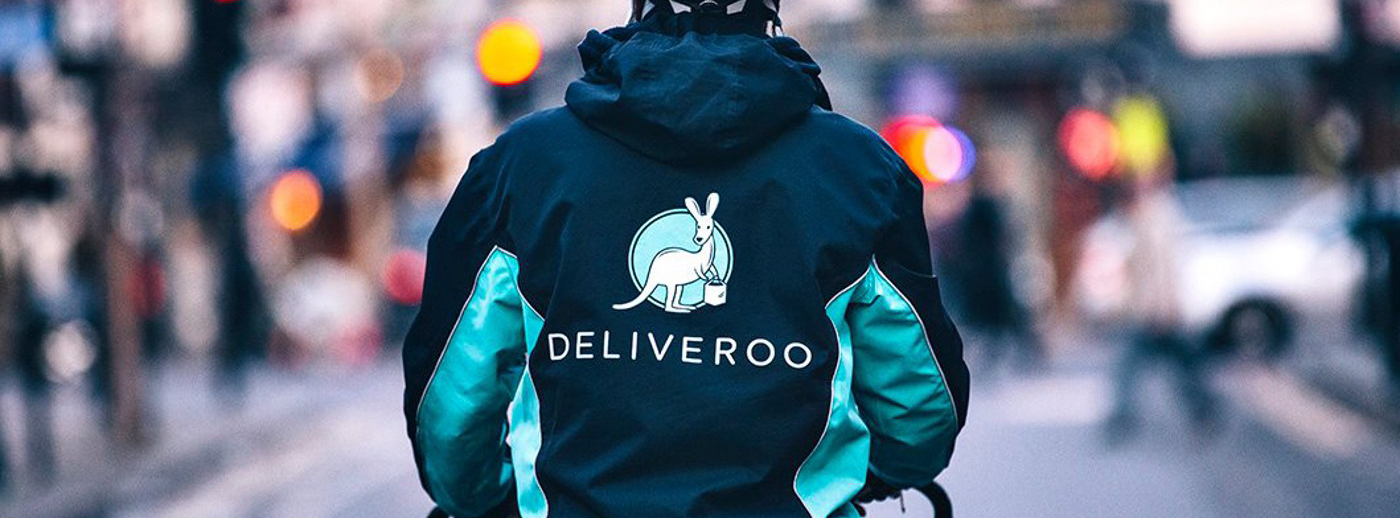 Deliveroo Rider on a street riding with a jacket on