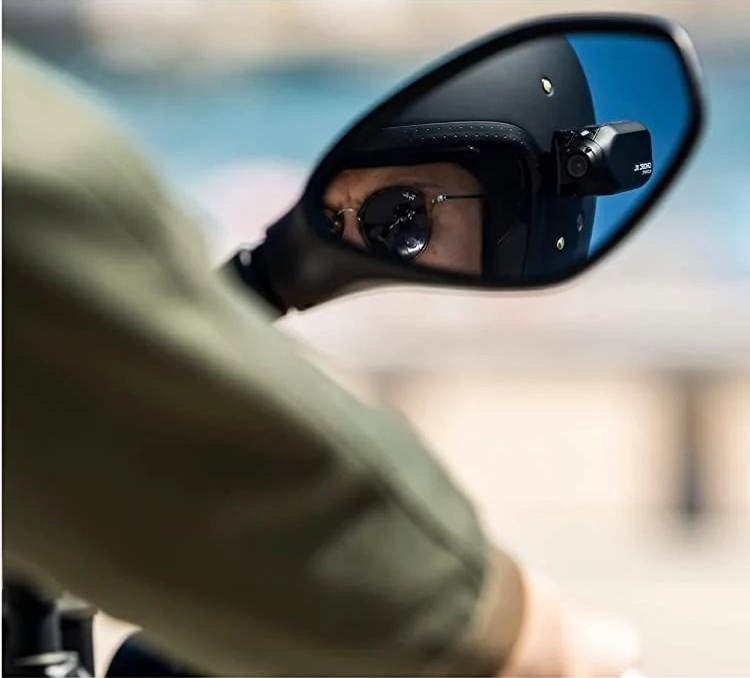 Motorcyclist wearing as open face Helmet with a Ghost XL Pro Helmet Camera on the side.